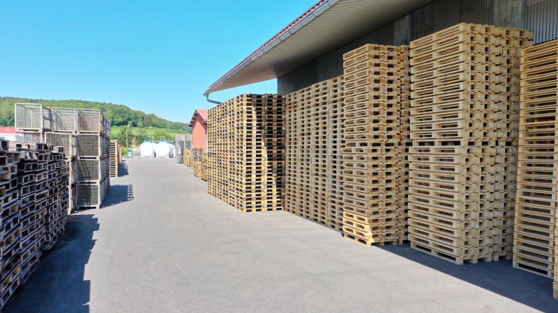 Lagerhalle von außen mit gestapelten Paletten